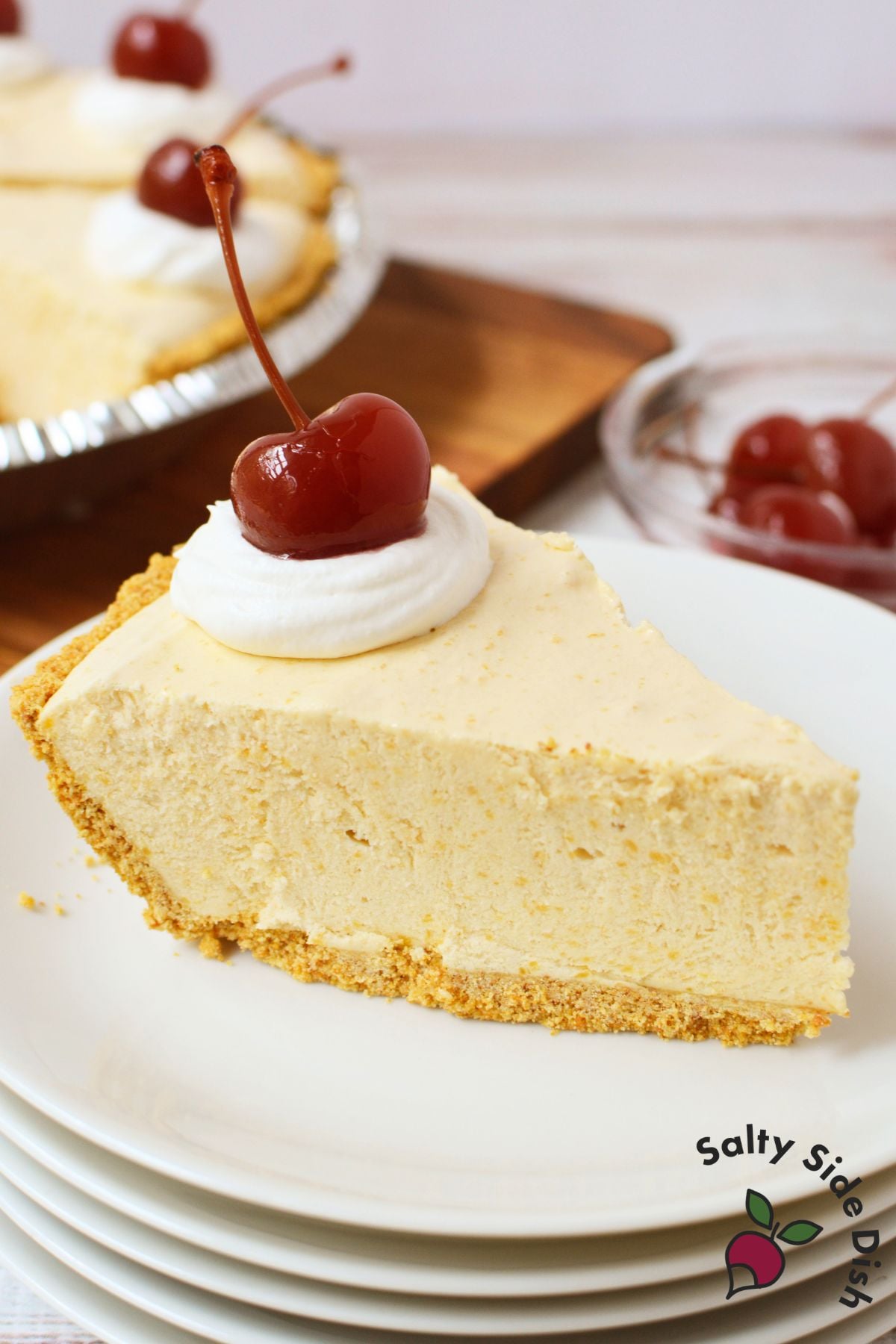 Slice of root beer float pie on a plate with whipped cream and cherry