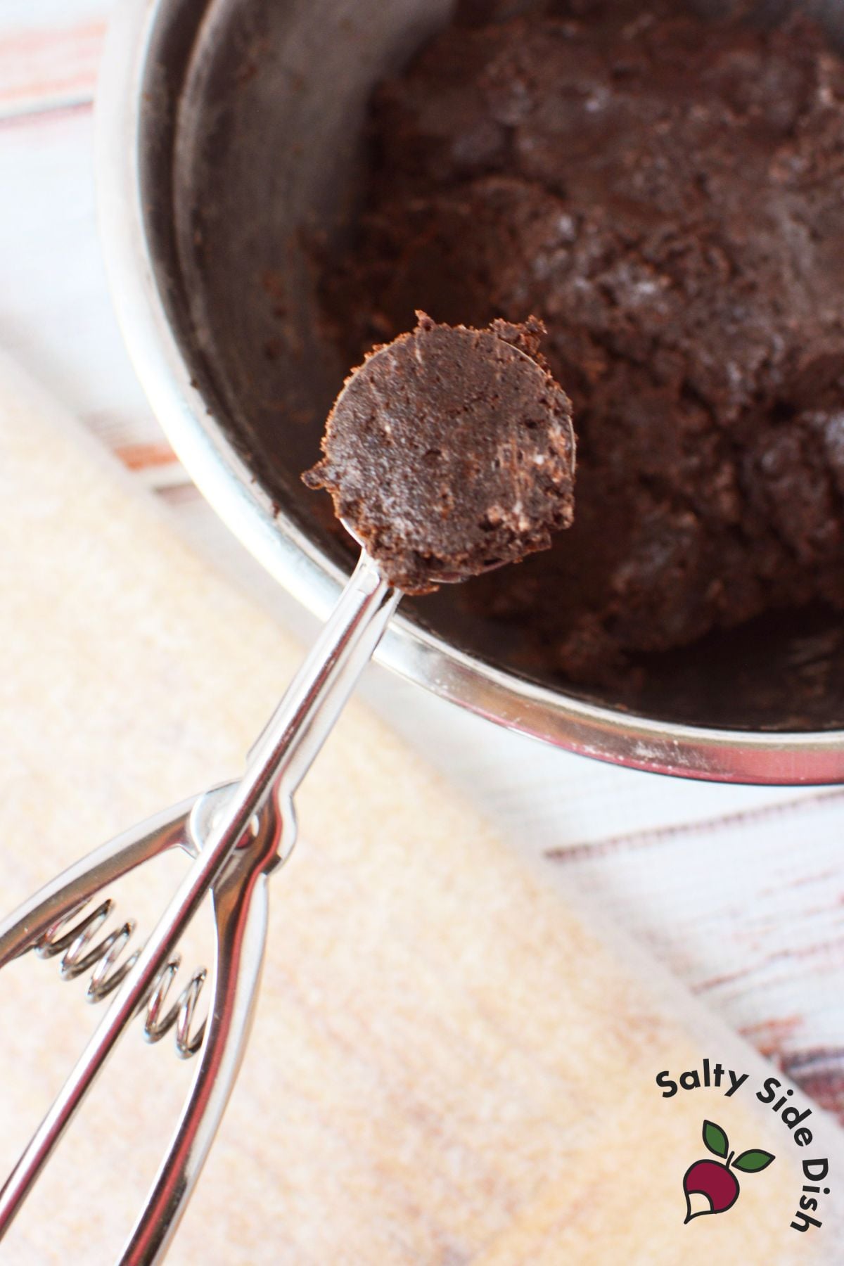 Scooping the Oreo truffle mixture into even portions before rolling into balls.