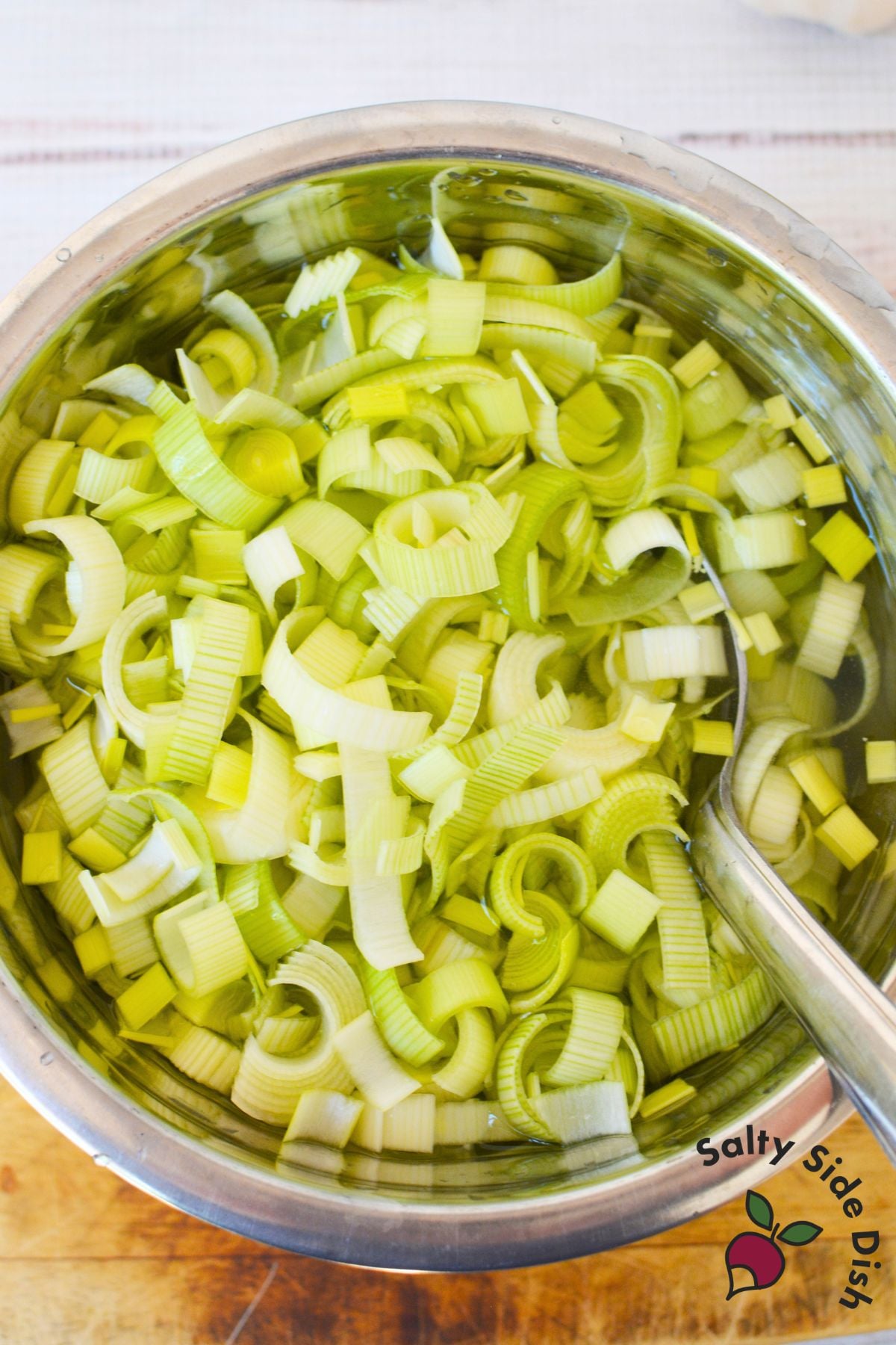 Chopped leeks soaking in a bowl of cold water to remove sand and dirt