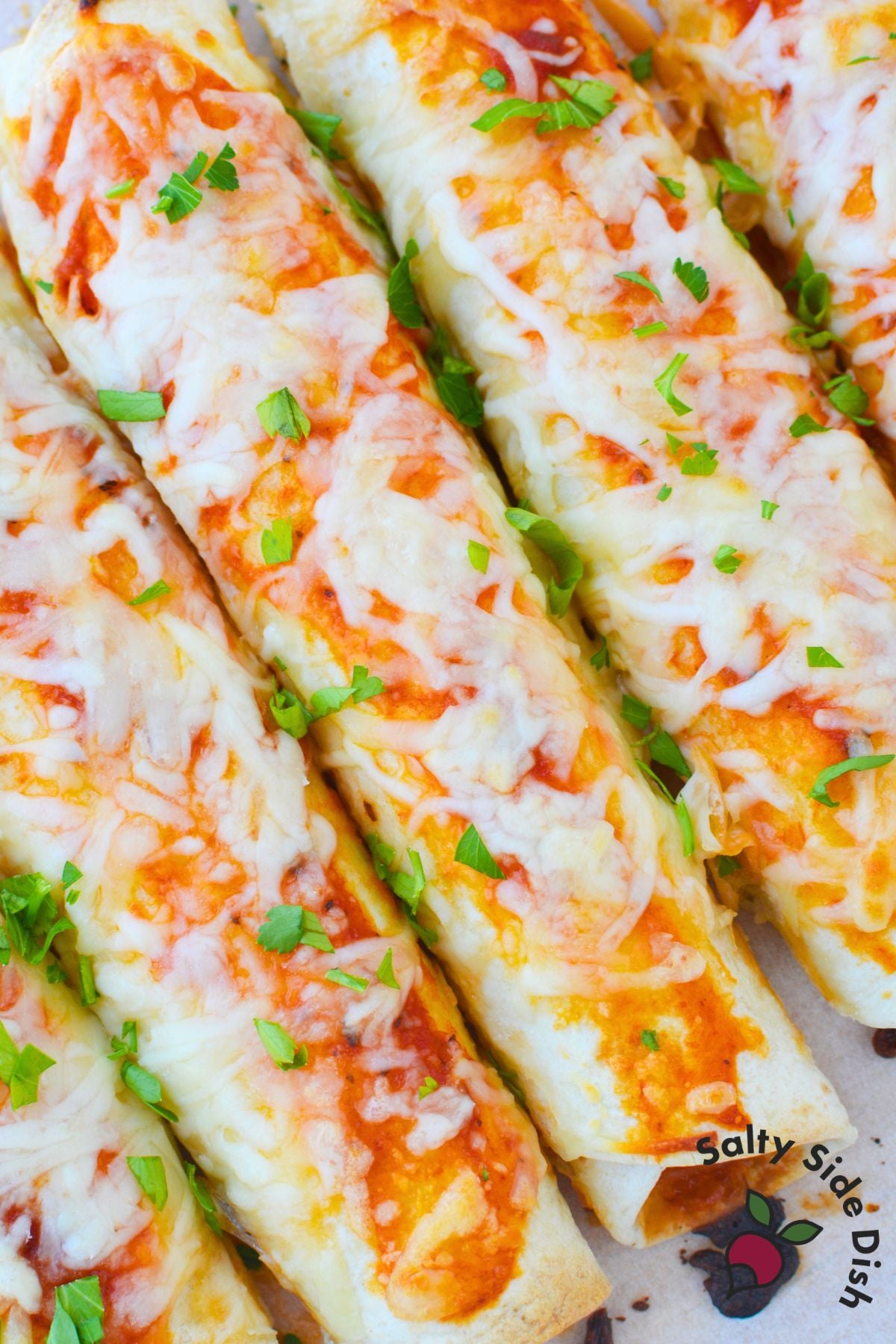Easy lasagna rolls with tortillas topped with pasta sauce, melted mozzarella, and fresh parsley