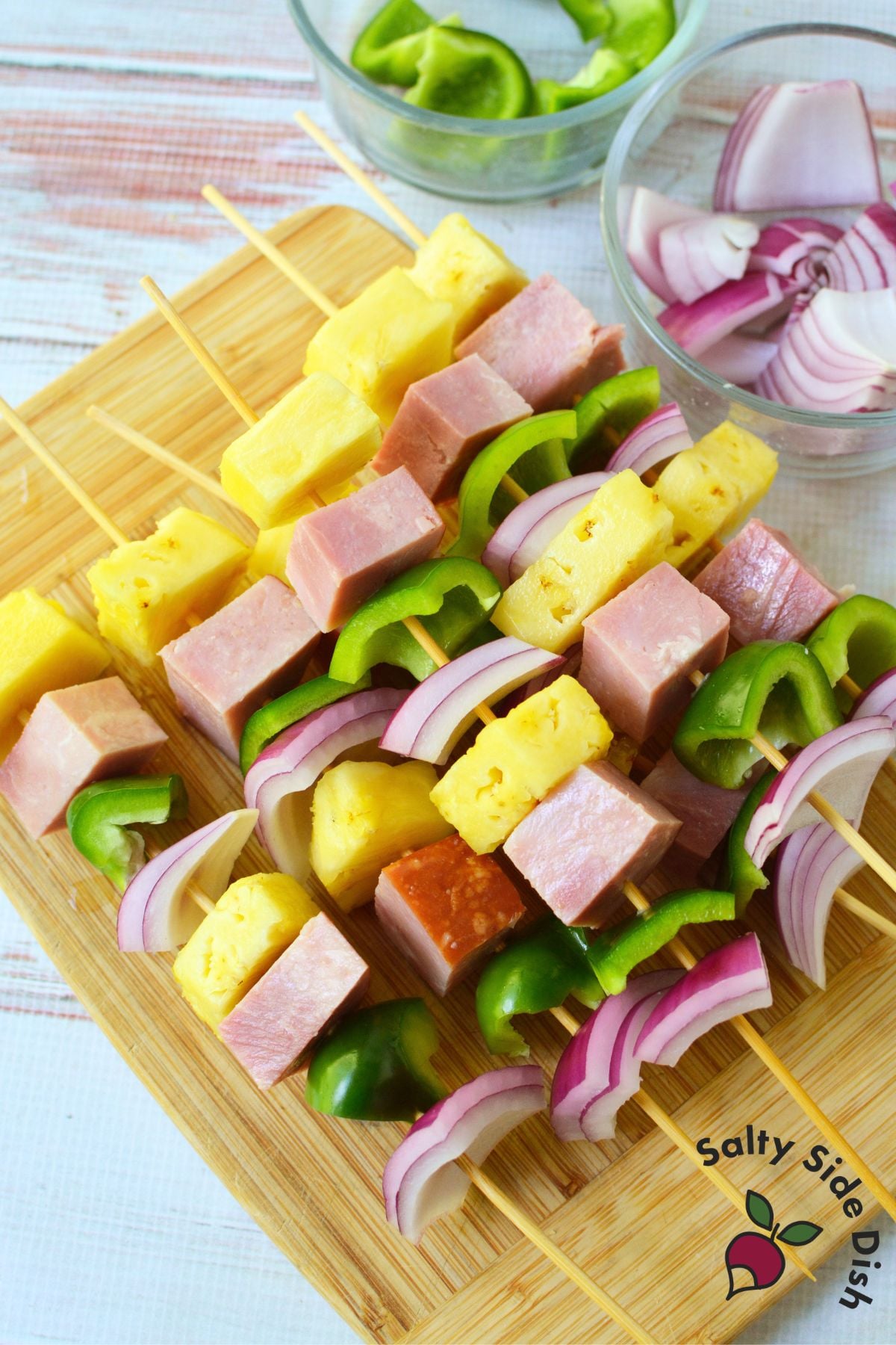 Ham, pineapple, green pepper and red onion threaded onto bamboo skewers