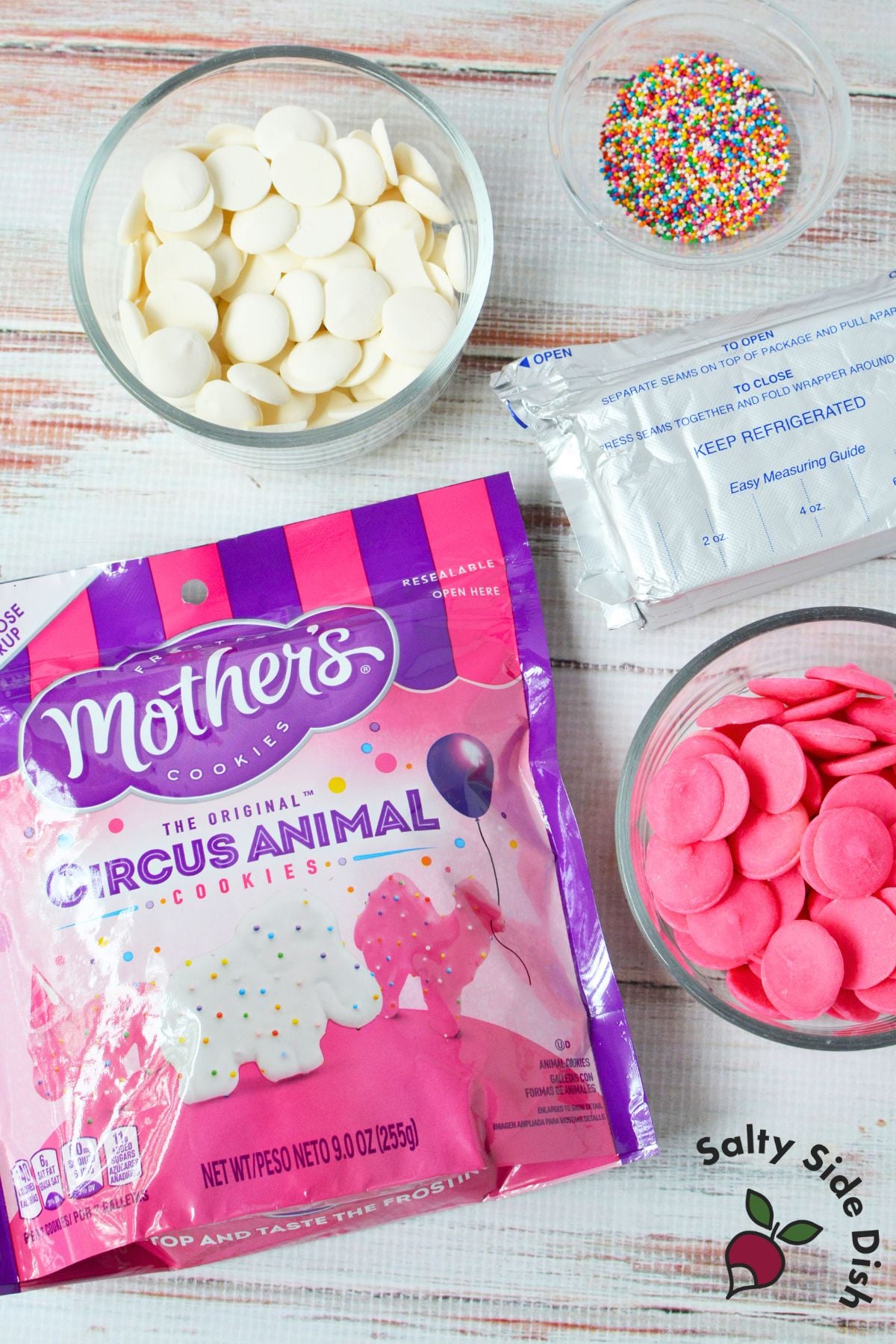 Ingredients for Circus Animal Cookie Truffles including frosted animal cookies, cream cheese, candy melts, and sprinkles