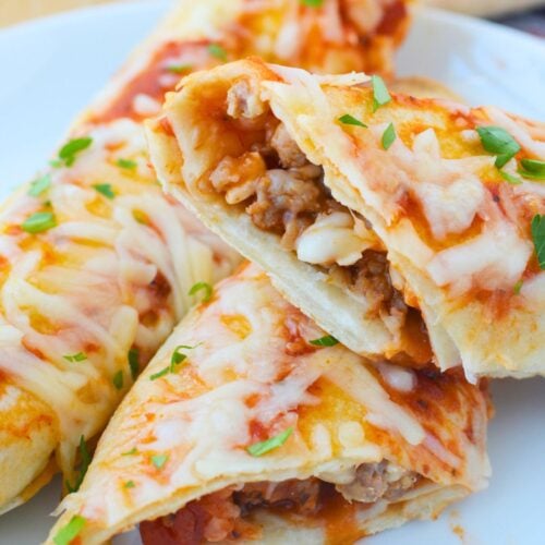 Sliced tortilla lasagna rolls showing Italian sausage, pasta sauce, and mozzarella cheese filling