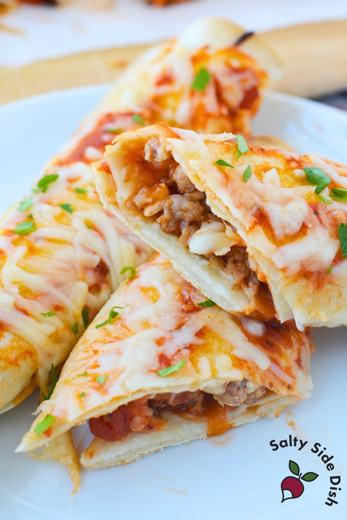 Sliced tortilla lasagna rolls showing Italian sausage, pasta sauce, and mozzarella cheese filling