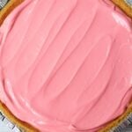Cherry Kool Aid pie filling spread evenly in a graham cracker crust