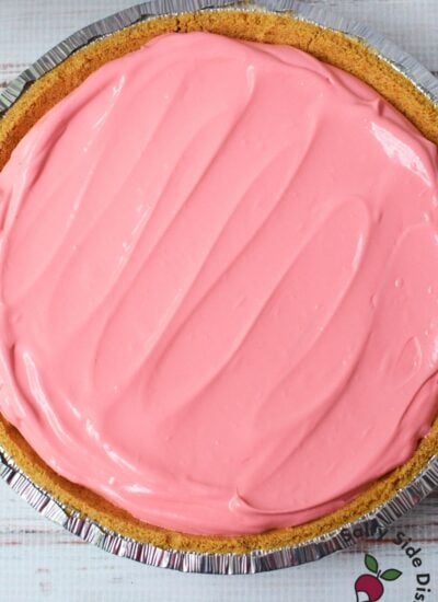 Cherry Kool Aid pie filling spread evenly in a graham cracker crust
