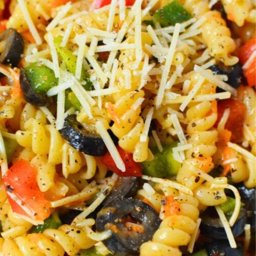 Close-up of Olive Garden pasta salad with rotini, vegetables, black olives, and shredded Parmesan cheese