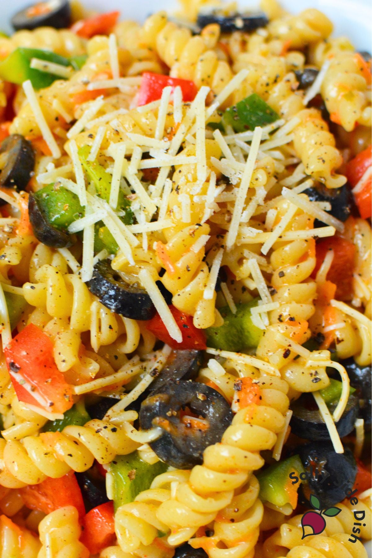 Close-up of Olive Garden pasta salad with rotini, vegetables, black olives, and shredded Parmesan cheese