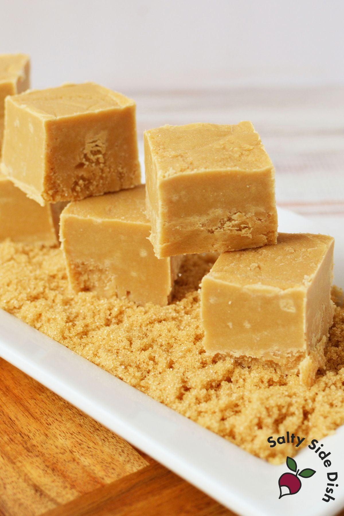 Thick squares of homemade brown sugar fudge served over a bed of light brown sugar.