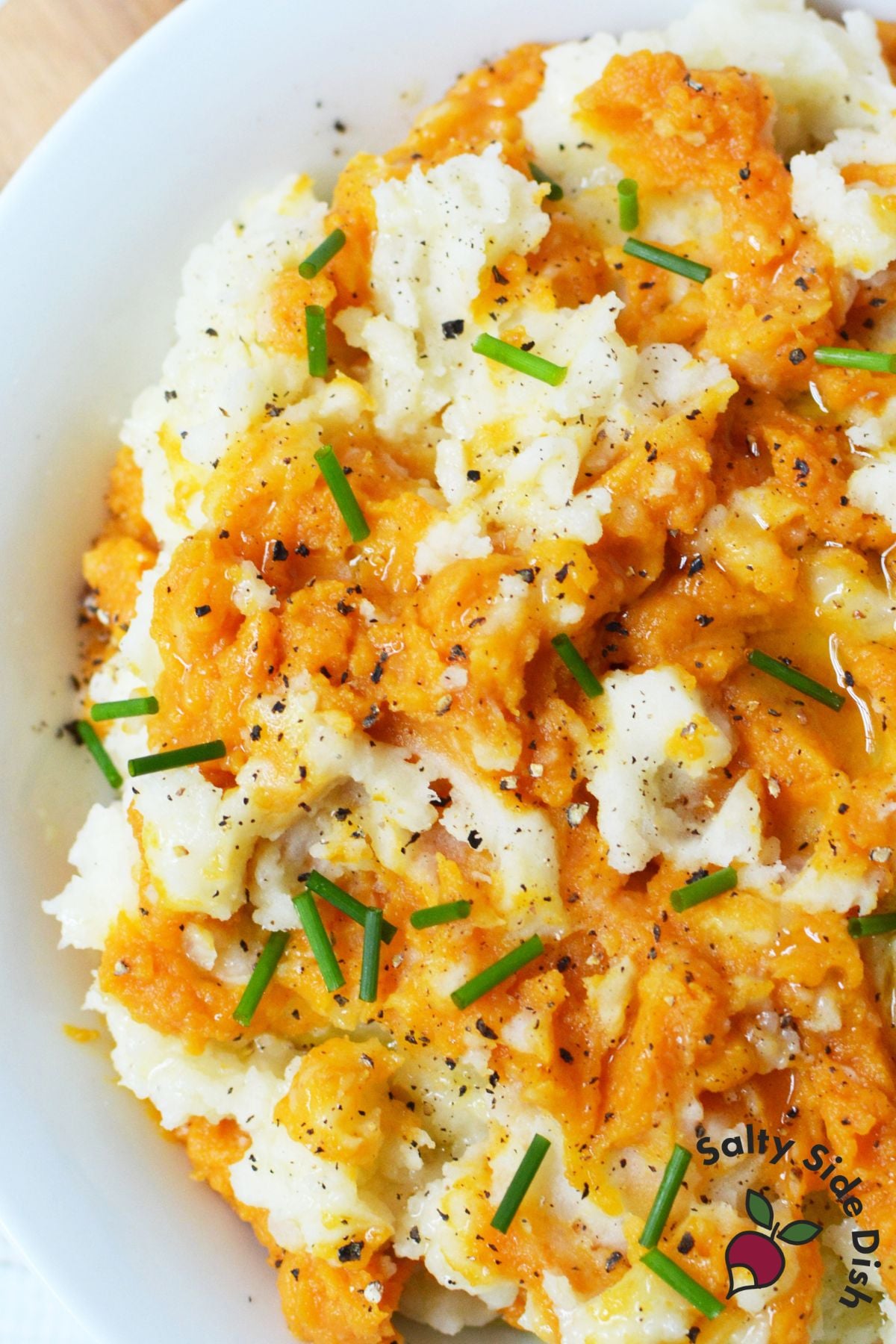 Pumpkin mashed potatoes swirled with pumpkin puree and topped with chives and black pepper