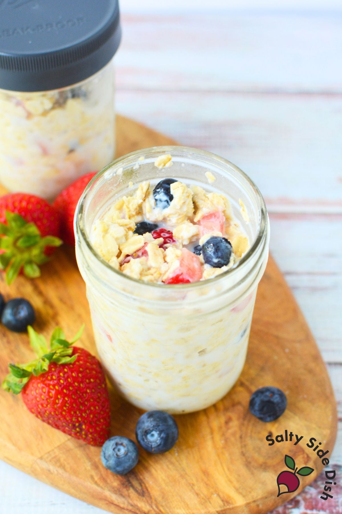 Berry overnight oats in a mason jar with fresh strawberries and blueberries for an easy make-ahead breakfast.