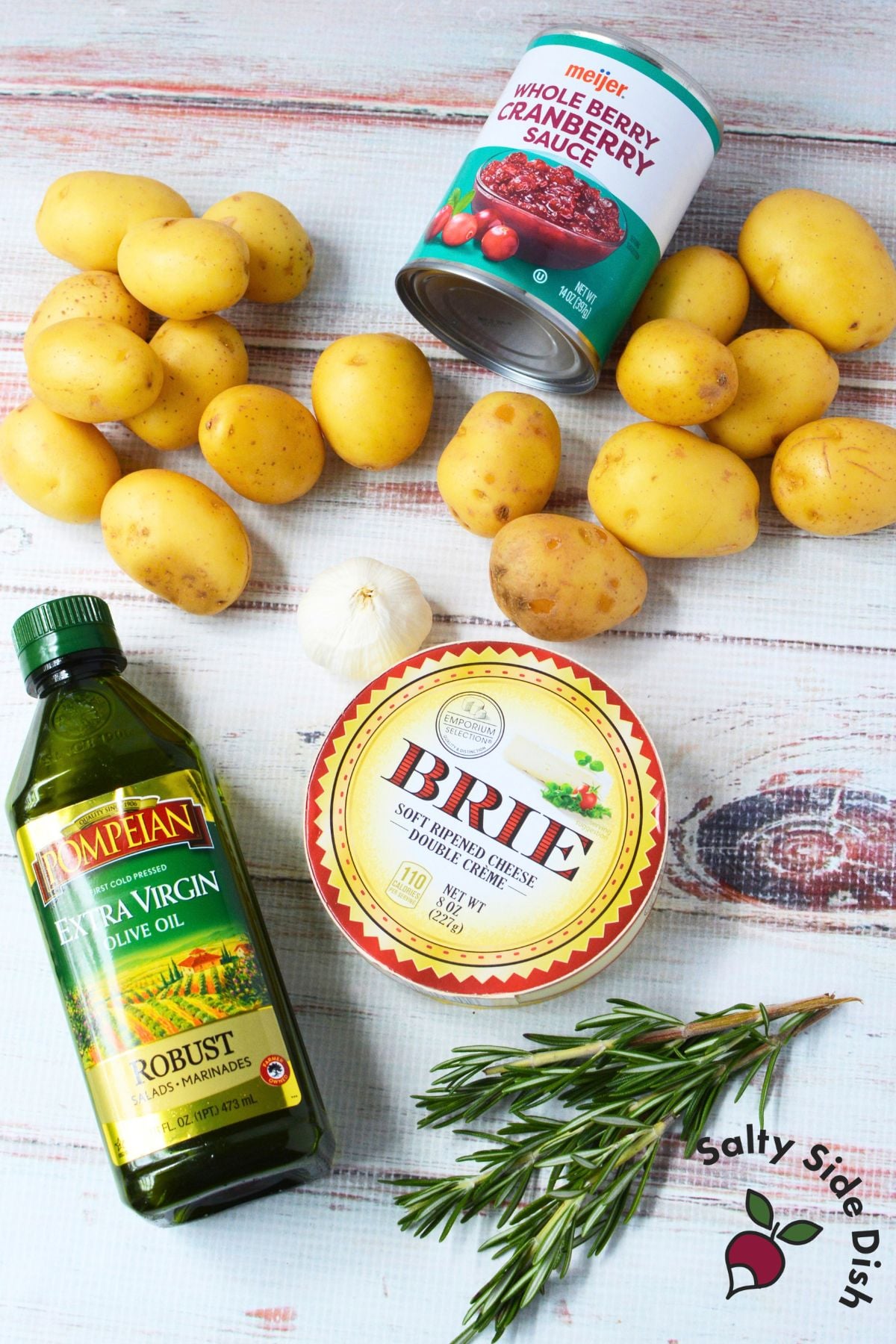 Ingredients for cranberry Brie smashed potatoes, including baby gold potatoes, whole berry cranberry sauce, Brie, olive oil, garlic, and rosemary.