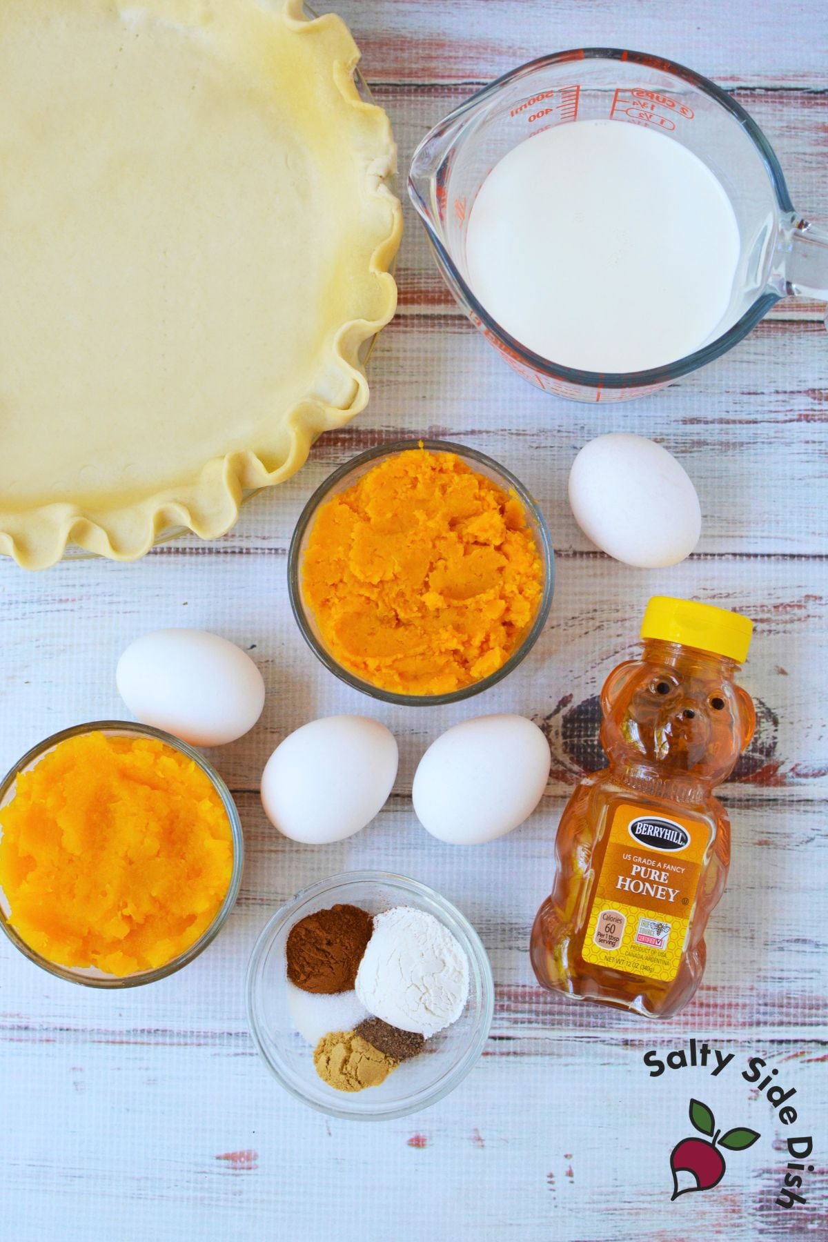 Ingredients for butternut squash pie including mashed butternut squash, mashed sweet potato, eggs, honey, half-and-half, spices, flour, and pie crust.