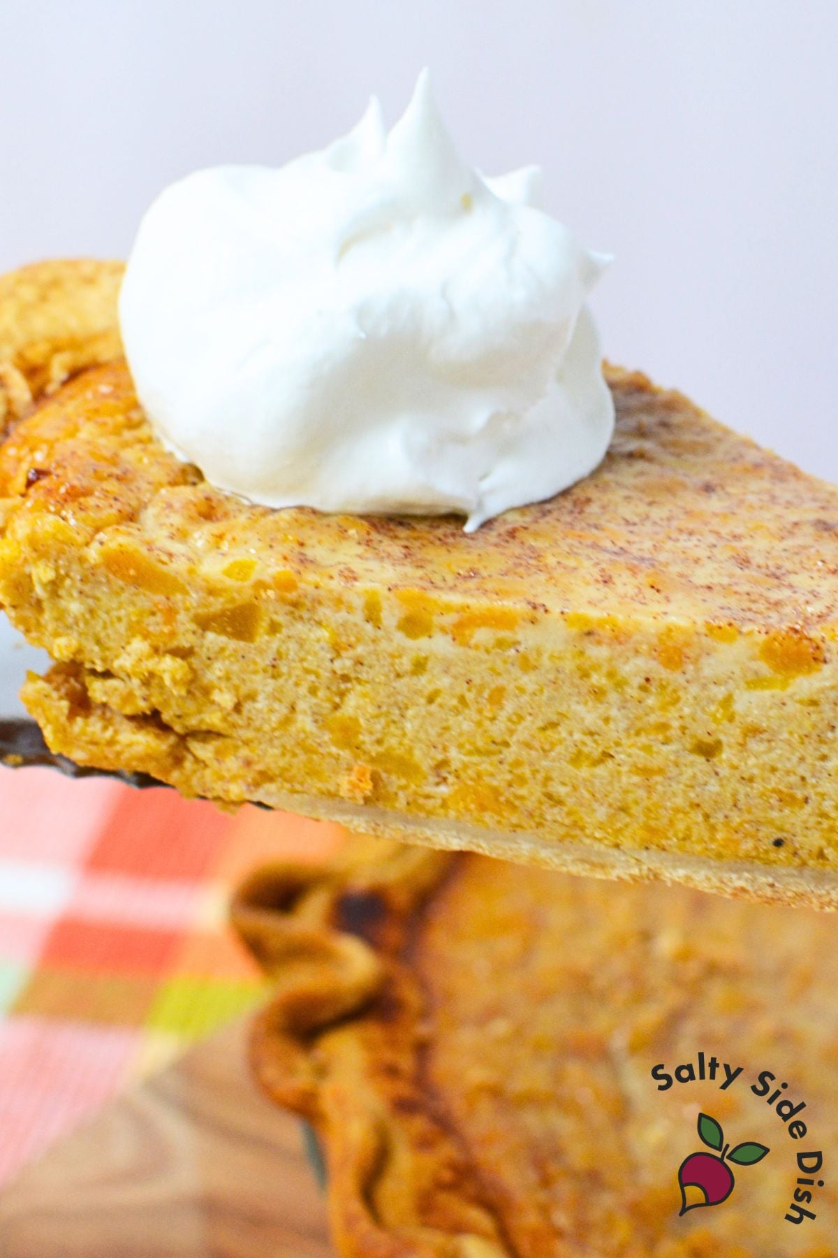 Close-up of creamy butternut squash and sweet potato pie filling topped with whipped cream.
