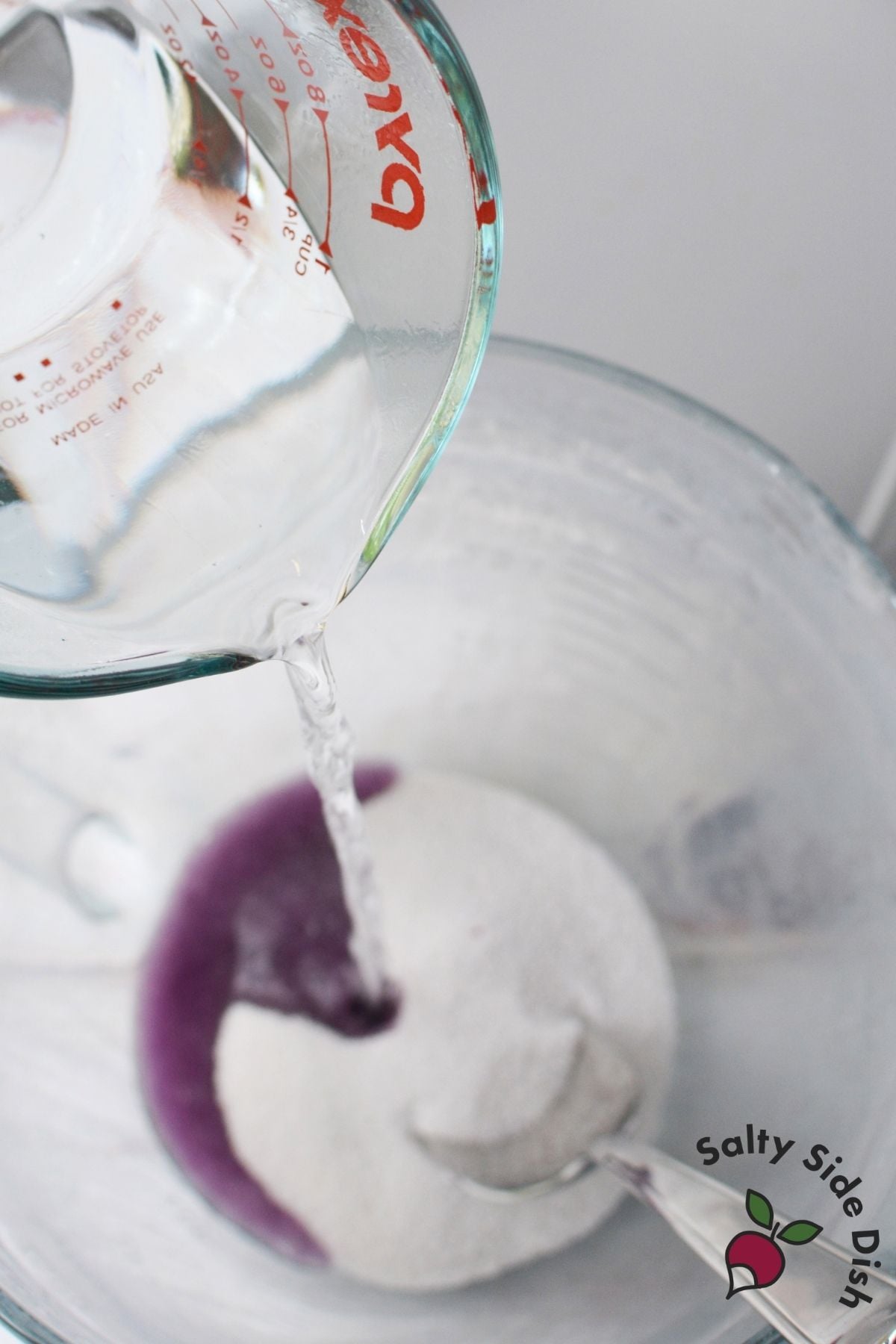 Boiling water being poured into flavored gelatin to make Jello roll ups