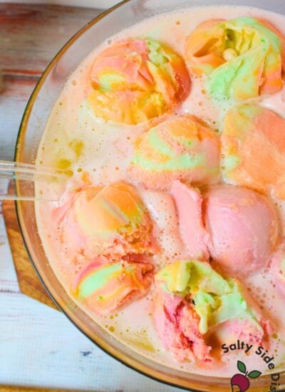 Rainbow sherbet punch in a glass bowl with colorful scoops of sherbet floating on top