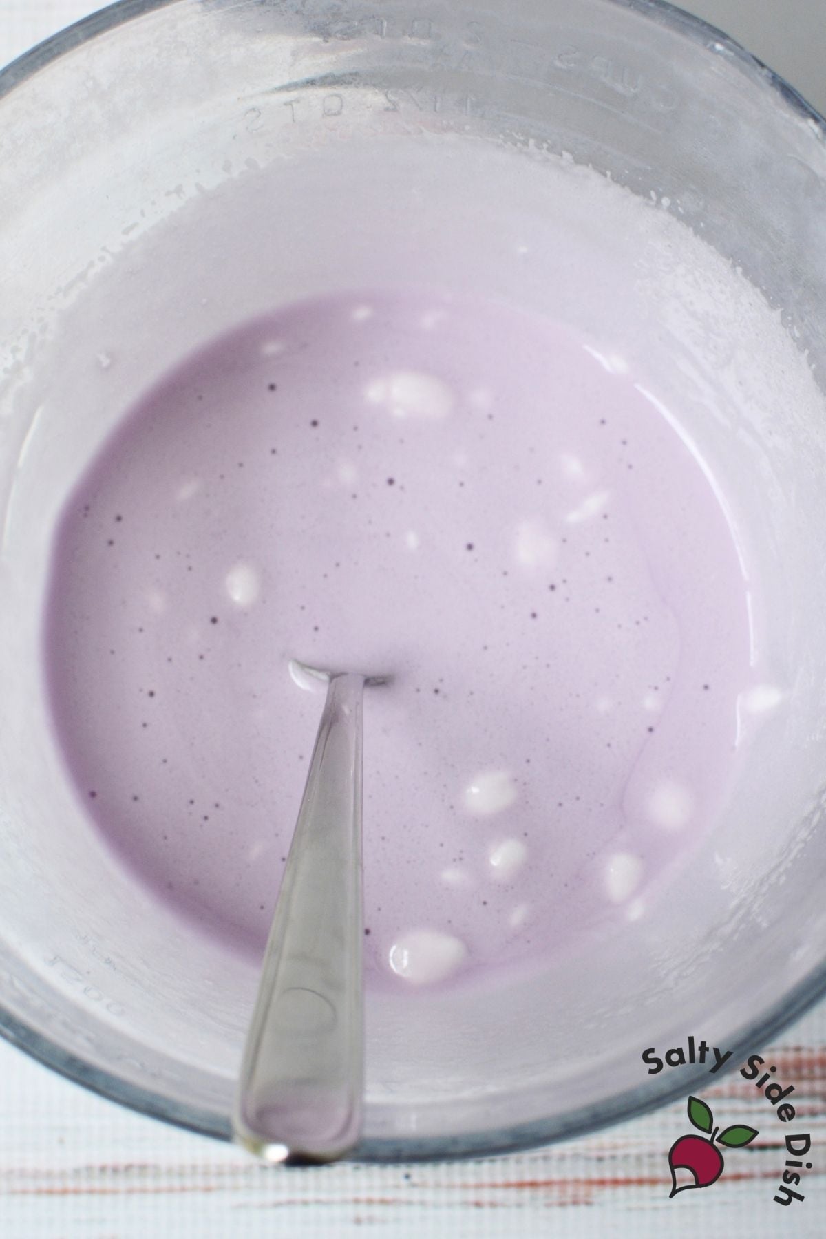 Melted marshmallow and grape Jello mixture stirred together in a mixing bowl