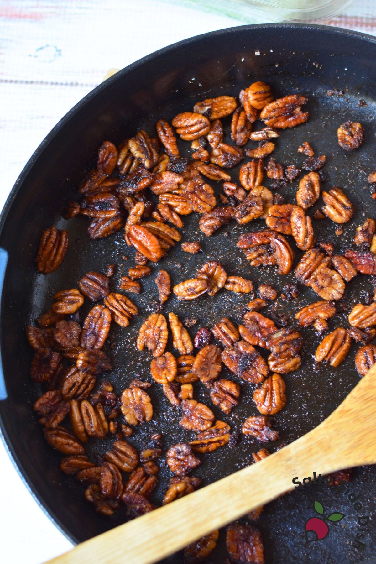 Spiced balsamic pecans toasting in a skillet for fall pear salad