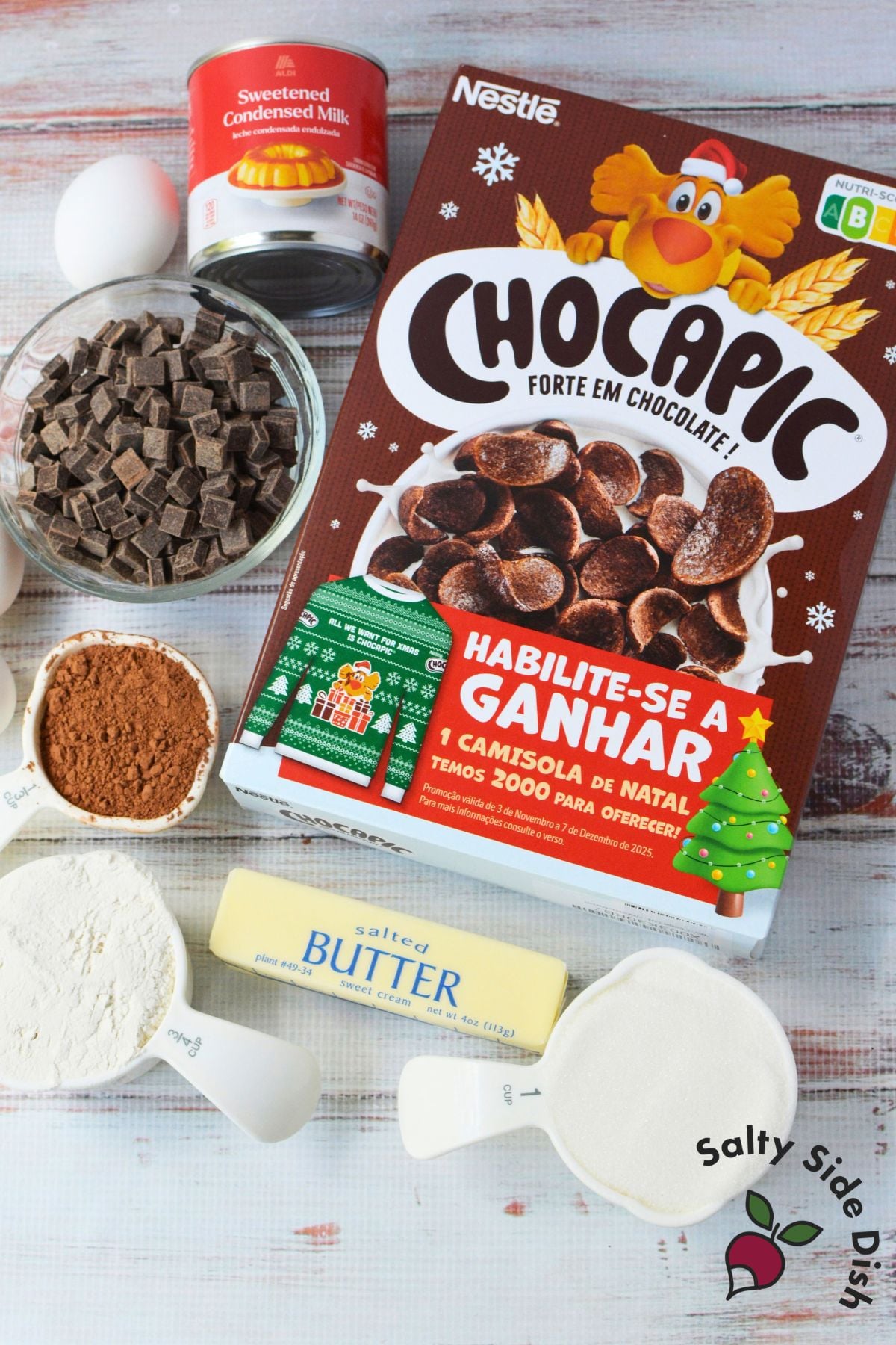 Ingredients for pinecone brownies including chocolate chunks, butter, sugar, cocoa, flour, sweetened condensed milk, eggs, and Chocapic cereal.
