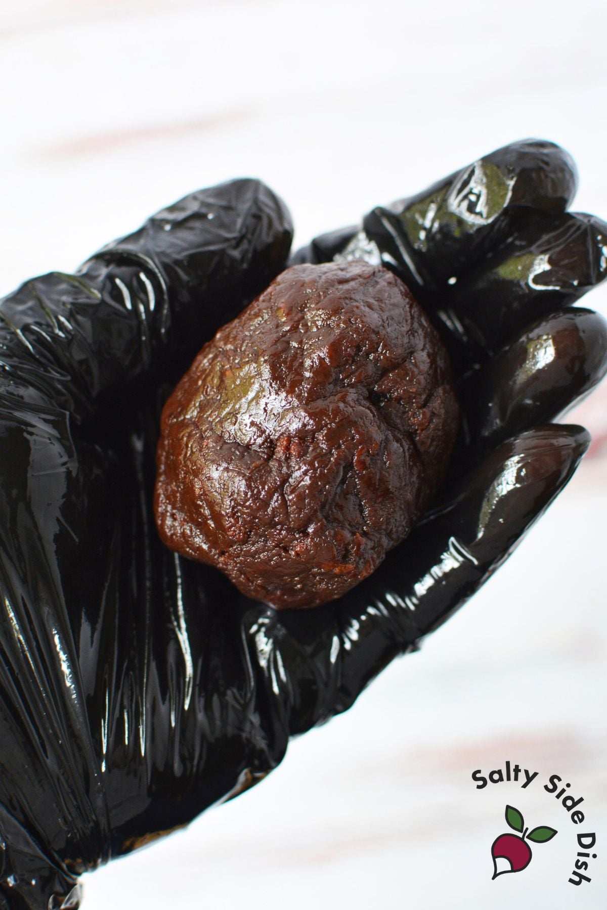 Hand shaping brownie mixture into an egg-shaped pinecone base before decorating.