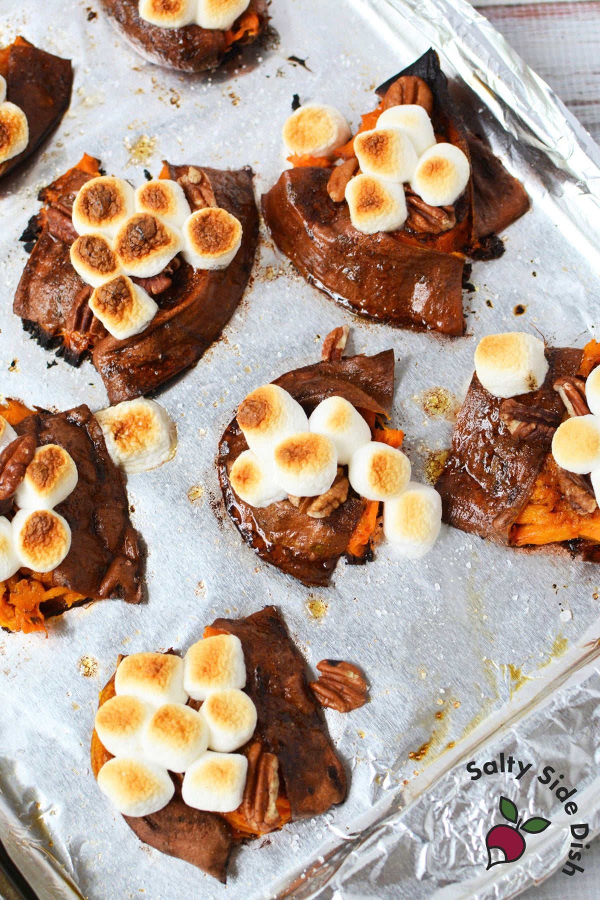 Smashed sweet potatoes with marshmallows and pecans broiled on a foil-lined baking sheet