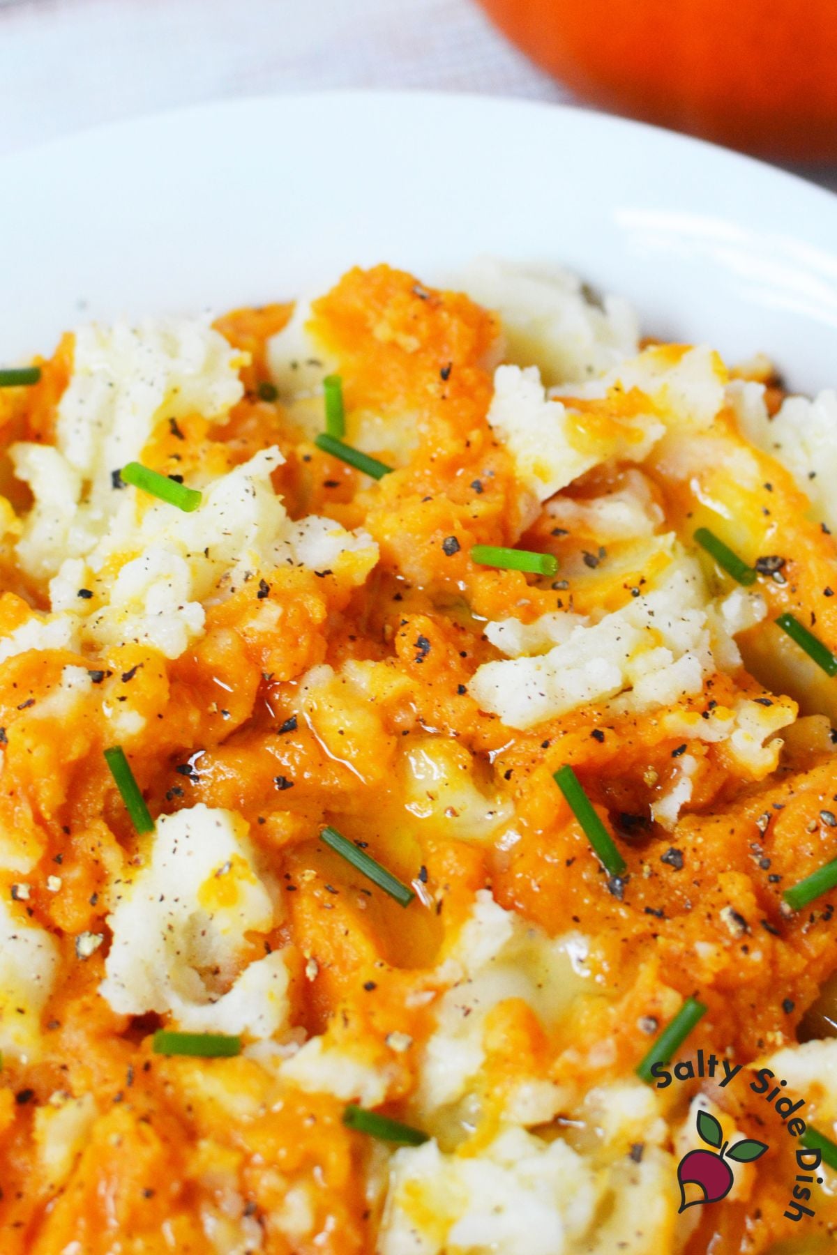 Thanksgiving pumpkin mashed potatoes with savory pumpkin, olive oil, chives, and cracked black pepper