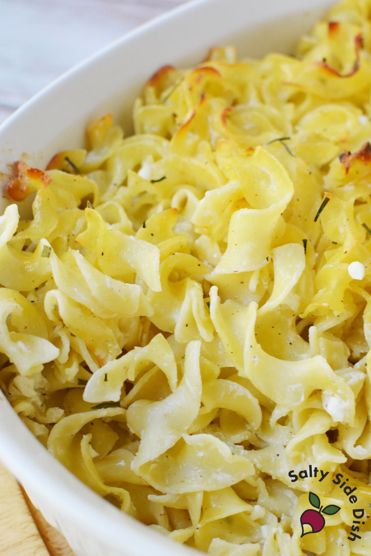 Forkful of Jackie Kennedy Casserole showing tender egg noodles coated with cottage cheese, sour cream, and fresh chives.