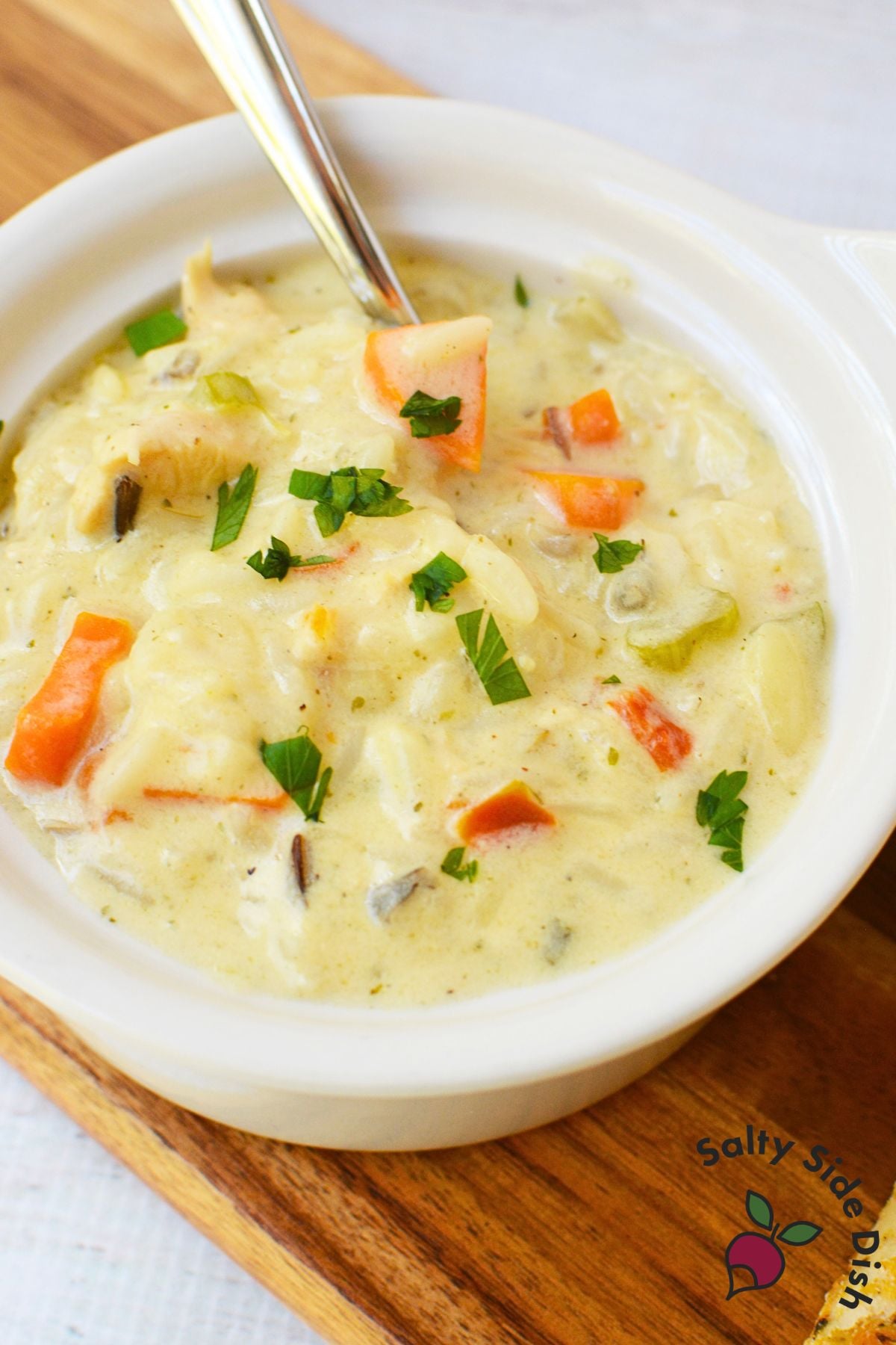 Creamy chicken wild rice soup with tender chicken, carrots, celery, and wild rice in a white bowl