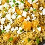 Close-up of fluffy quinoa mixed with tender butternut squash, crumbled feta cheese, and fresh parsley.