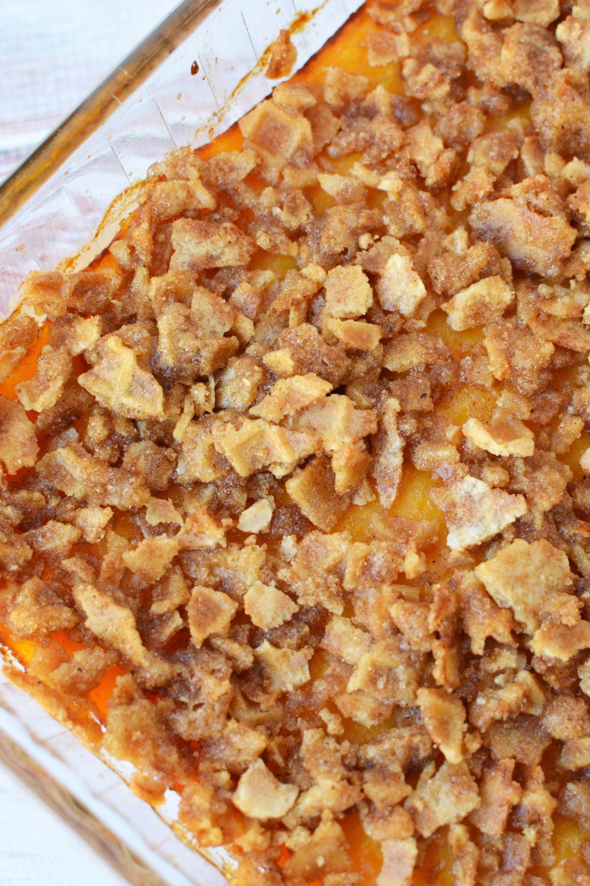 Homemade butternut squash casserole in a glass baking dish with a golden brown, crunchy waffle cone topping.