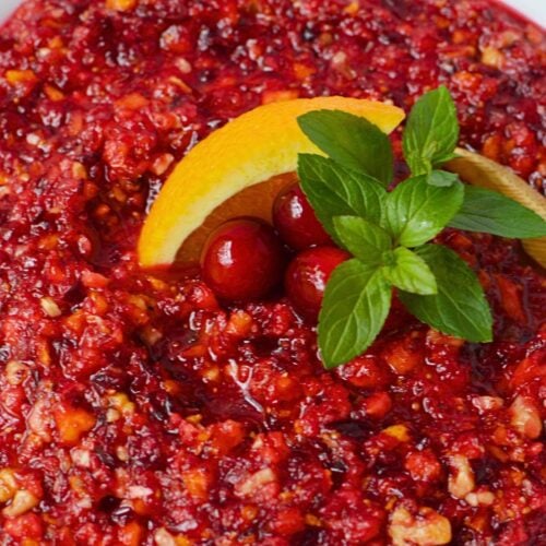 Cranberry orange relish with walnuts topped with fresh cranberries and an orange wedge