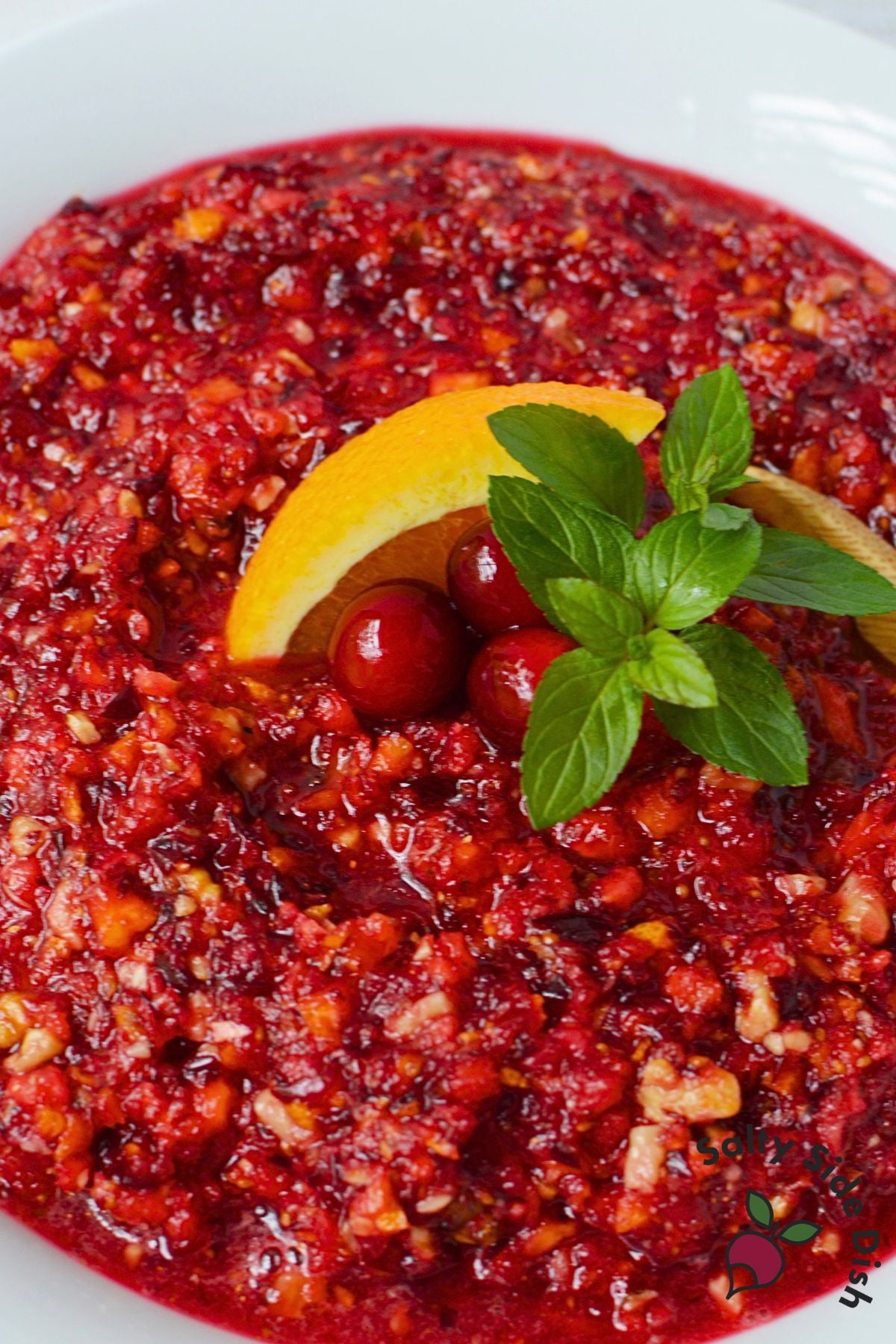Cranberry orange relish with walnuts topped with fresh cranberries and an orange wedge
