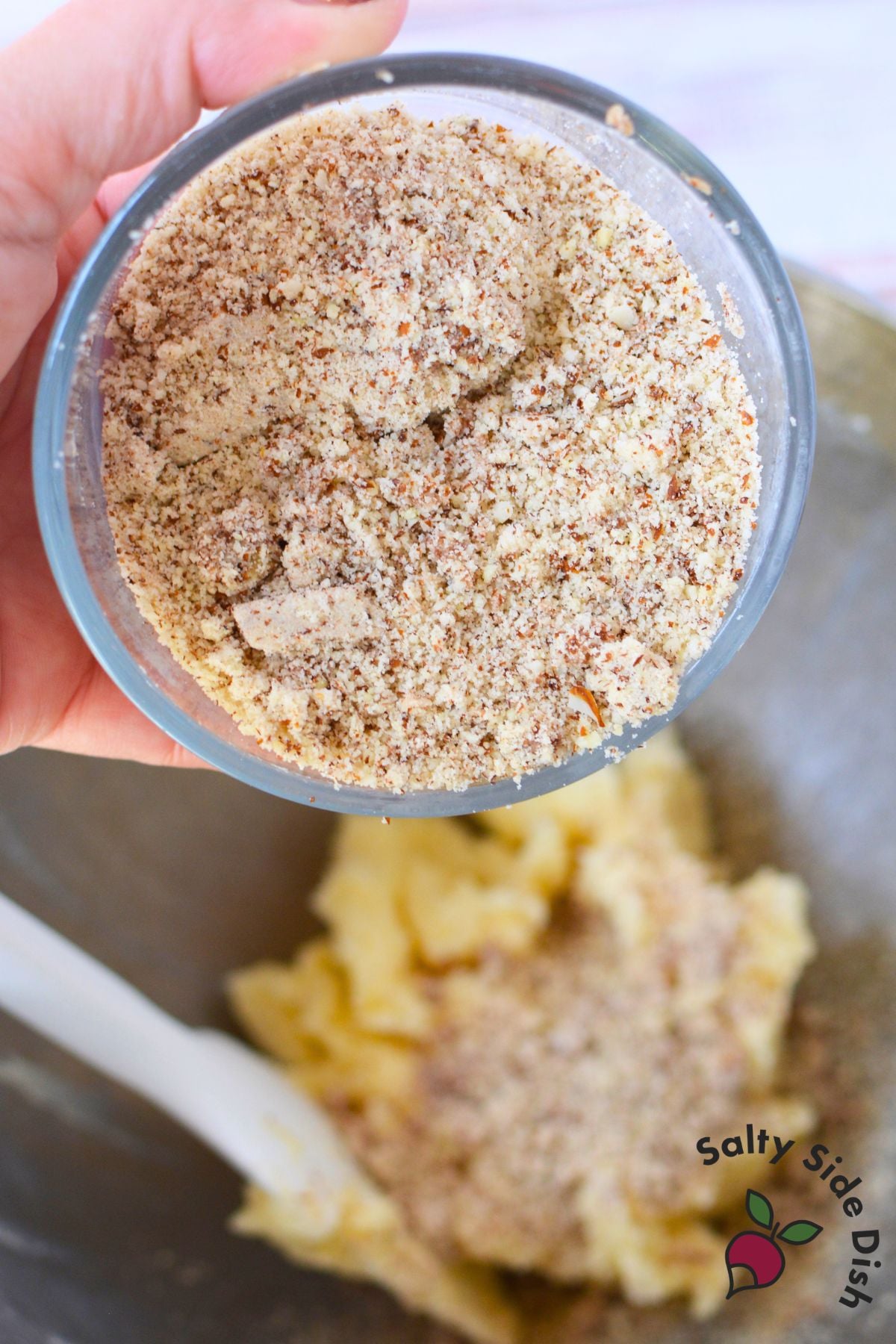 Close-up of finely ground almonds prepared for homemade almond snowball cookie dough using a nut grinder.