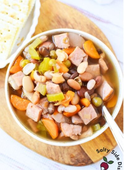 Bowl of homemade ham and bean soup with tender mixed beans, chopped ham, carrots, and celery in a savory broth.