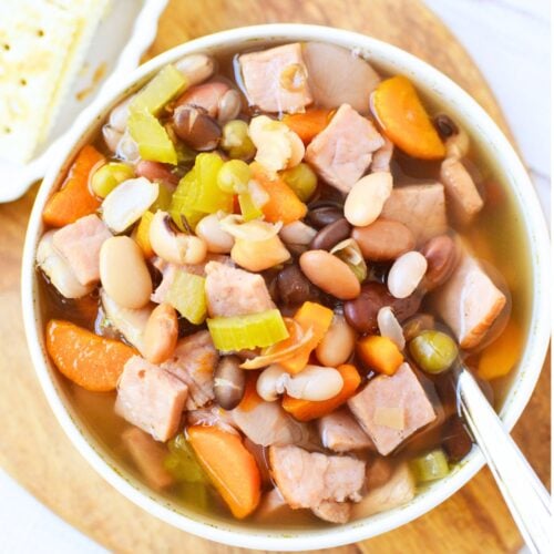 Bowl of homemade ham and bean soup with tender mixed beans, chopped ham, carrots, and celery in a savory broth.