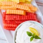 Watermelon, cantaloupe, pineapple, and honeydew fruit fries arranged on a platter with creamy lemon dip.
