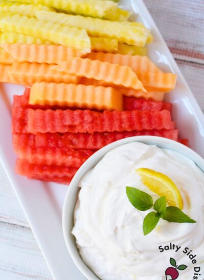 Watermelon, cantaloupe, pineapple, and honeydew fruit fries arranged on a platter with creamy lemon dip.
