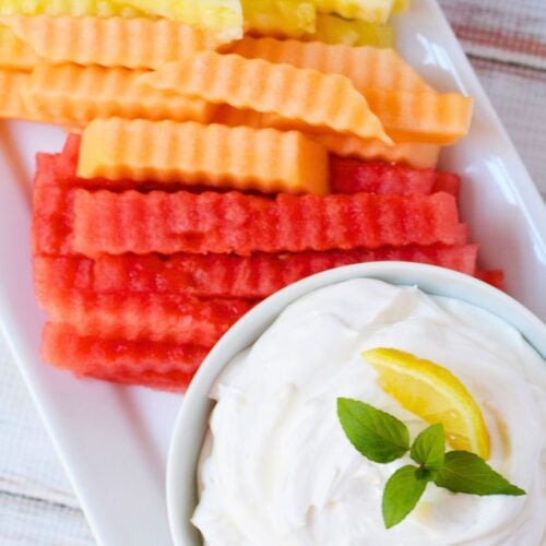 Watermelon, cantaloupe, pineapple, and honeydew fruit fries arranged on a platter with creamy lemon dip.