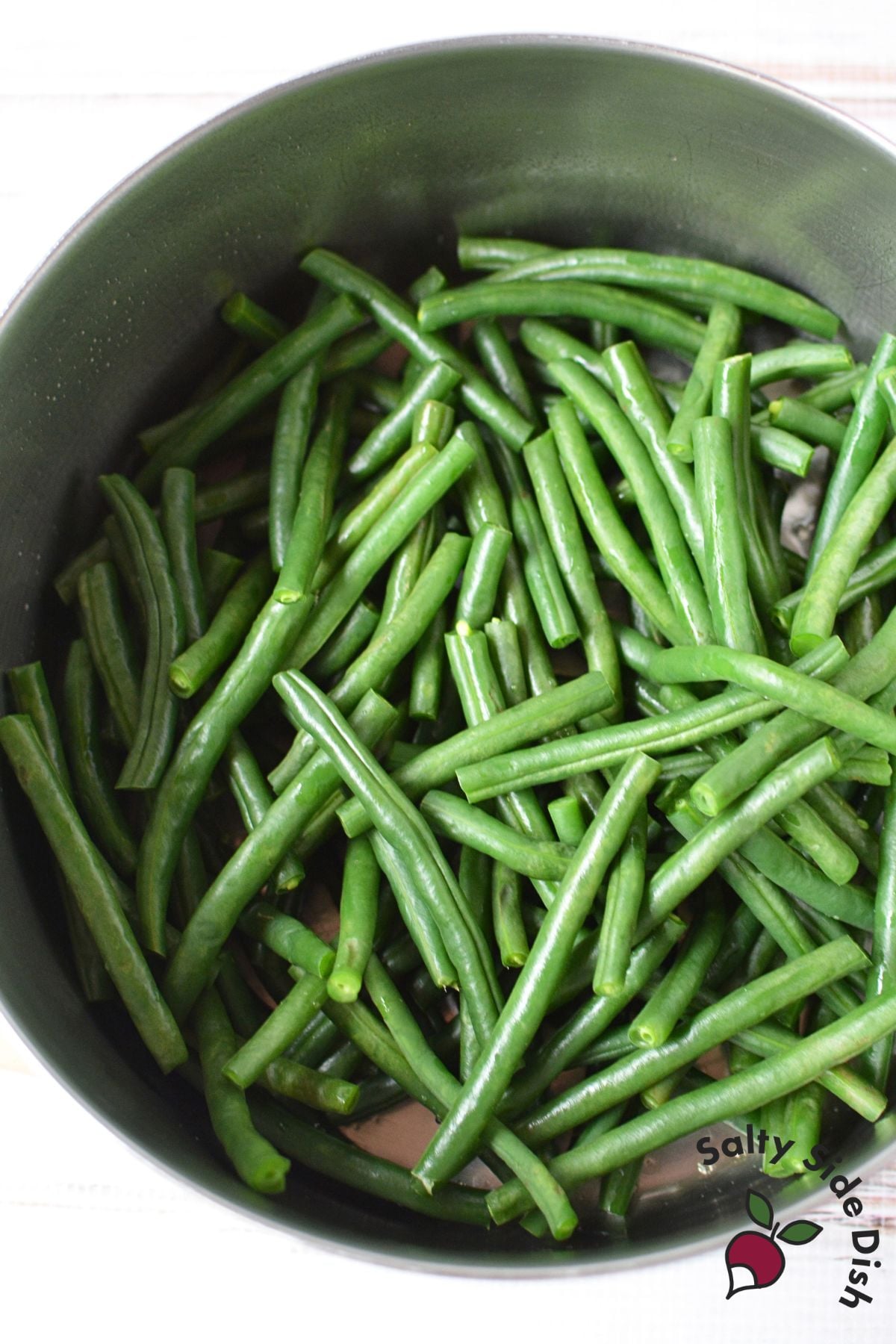 Fresh trimmed green beans in a large pot before cooking.