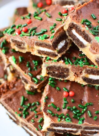 Close-up of Mini Oreo toffee bark pieces showing layers of chocolate sandwich cookies, buttery toffee, and melted chocolate topped with Christmas sprinkles.