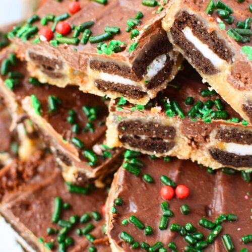 Close-up of Mini Oreo toffee bark pieces showing layers of chocolate sandwich cookies, buttery toffee, and melted chocolate topped with Christmas sprinkles.