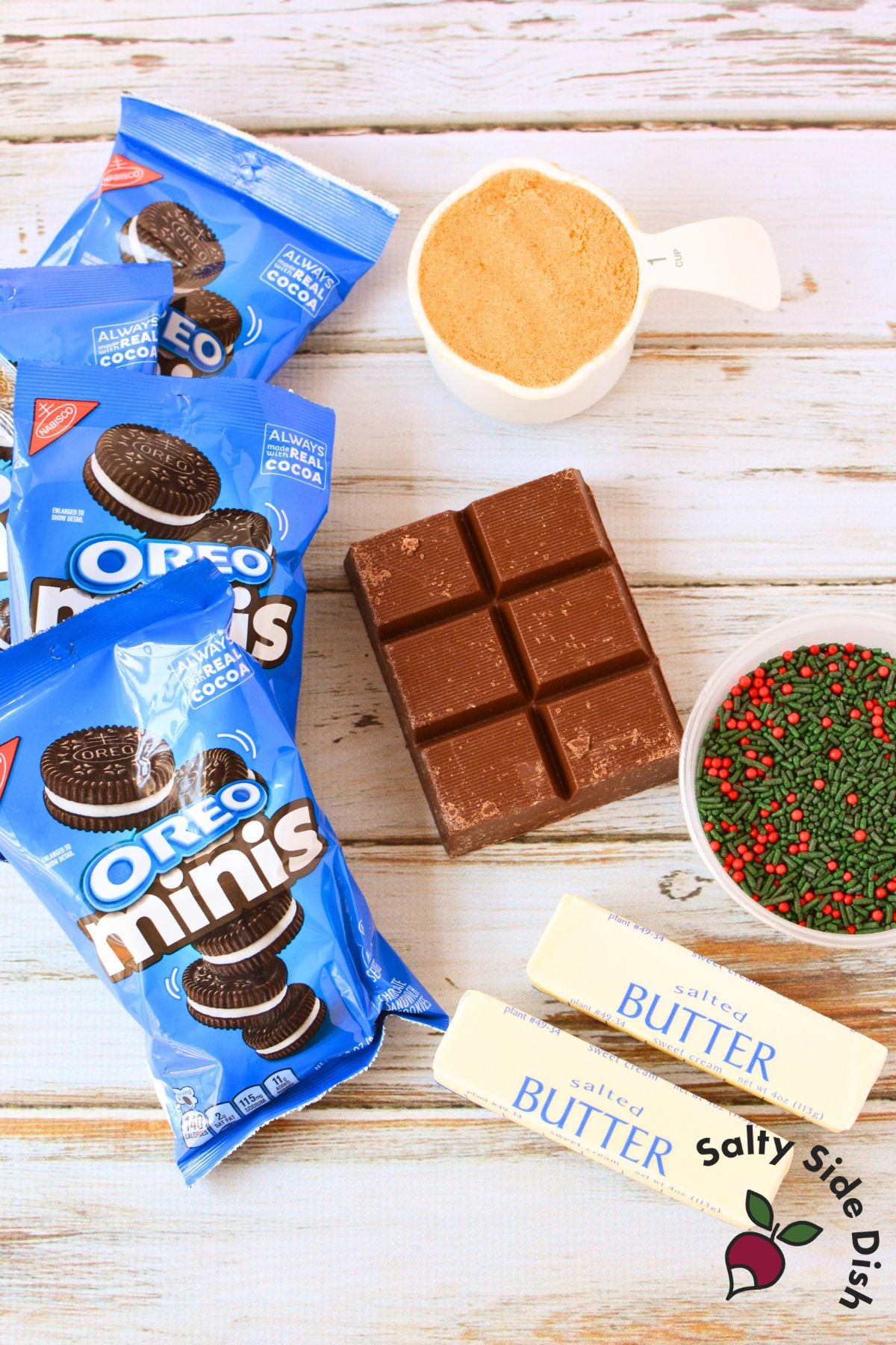 Ingredients for Oreo toffee bark including Mini Oreo cookies, butter, brown sugar, chocolate almond bark, and Christmas sprinkles.