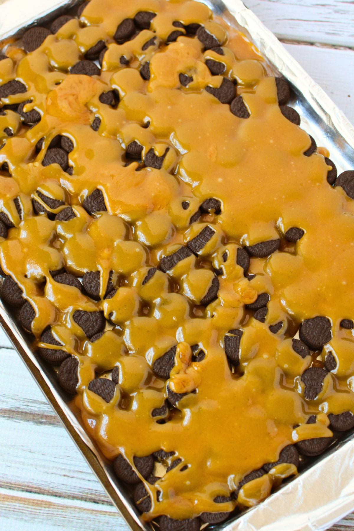 pouring toffee over cookies
