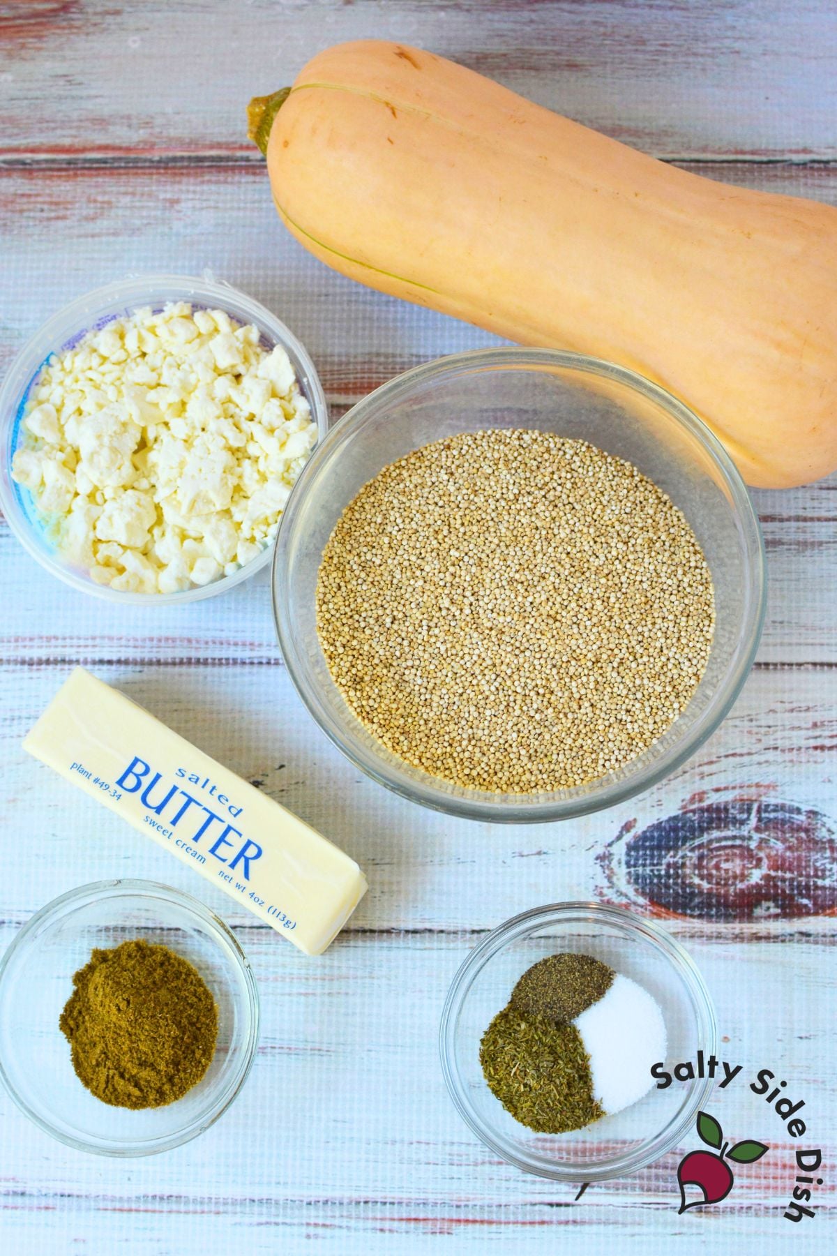 Ingredients for warm butternut squash quinoa salad including whole squash, dry quinoa, feta cheese, butter, cumin, and seasonings.