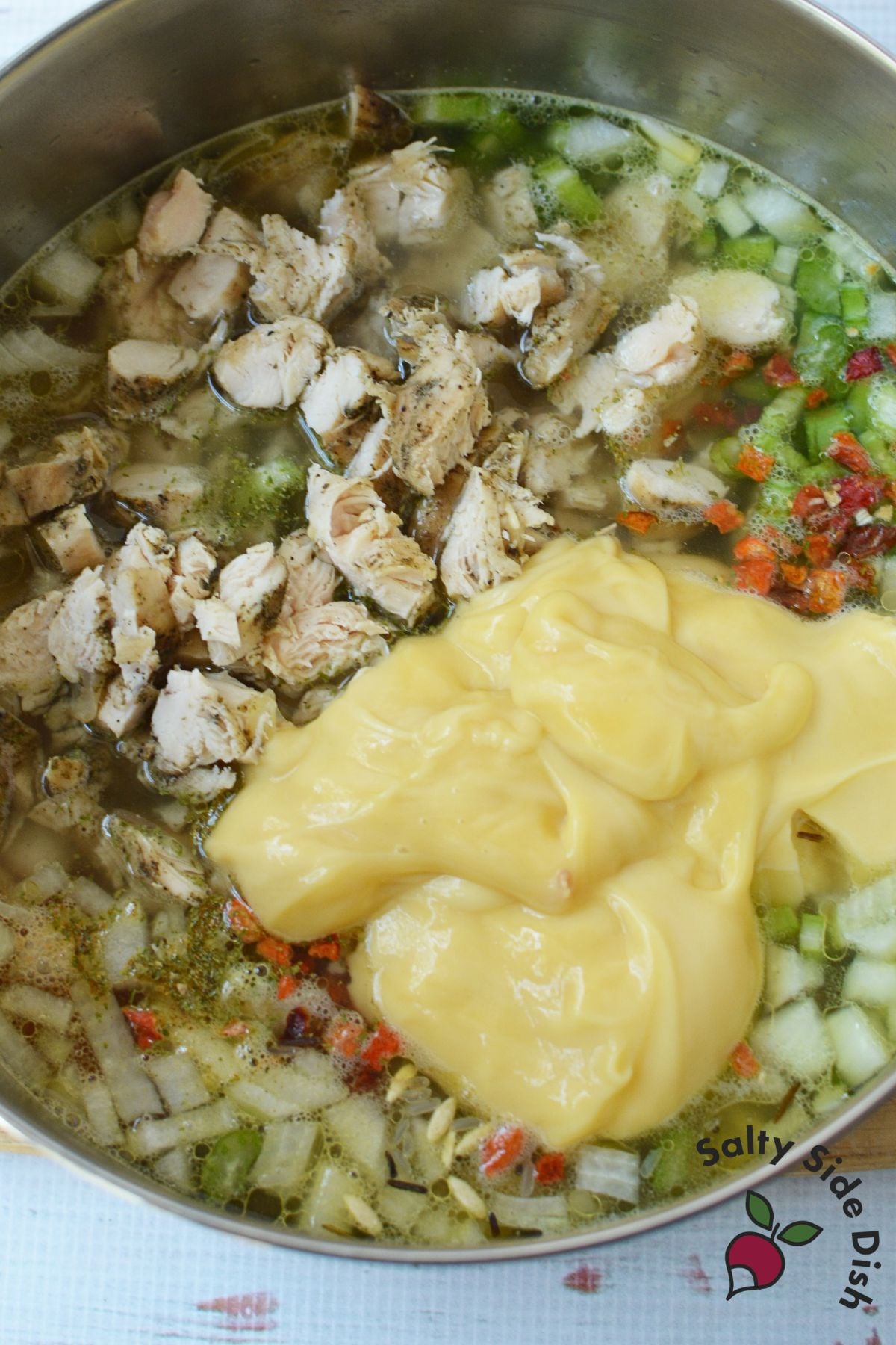 Cooked chicken, vegetables, wild rice, and cream of chicken soup combined in a stockpot before cooking